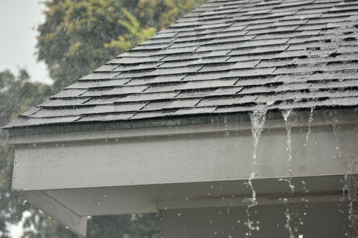 Heavy rain running off a shingle roof and gutter.