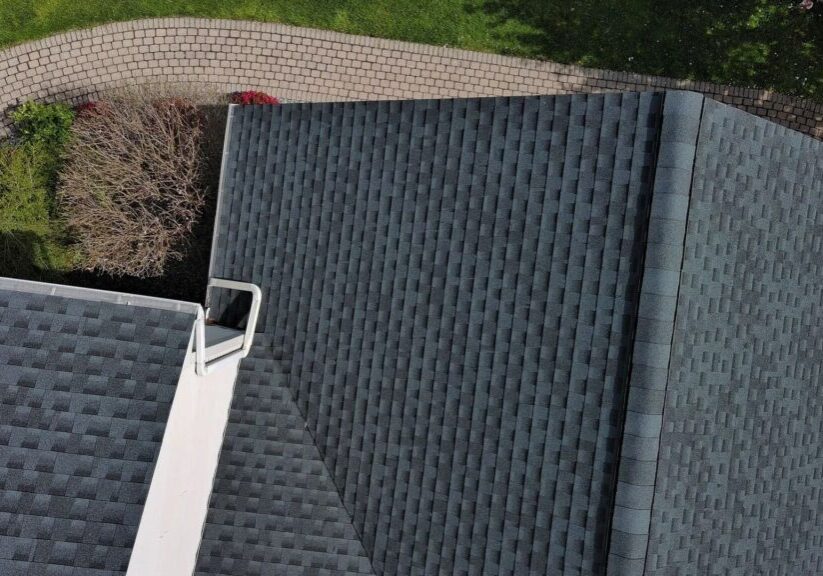 Overhead view of an asphalt shingle roof with a metal vent.