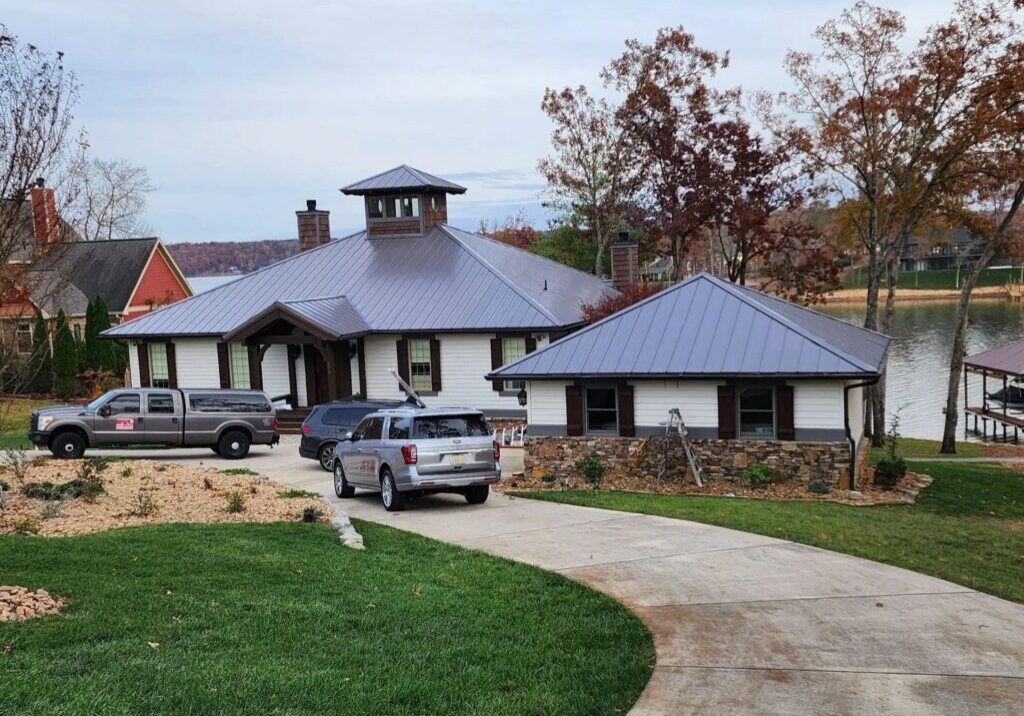 Waterfront home with a metal roof and paved driveway.